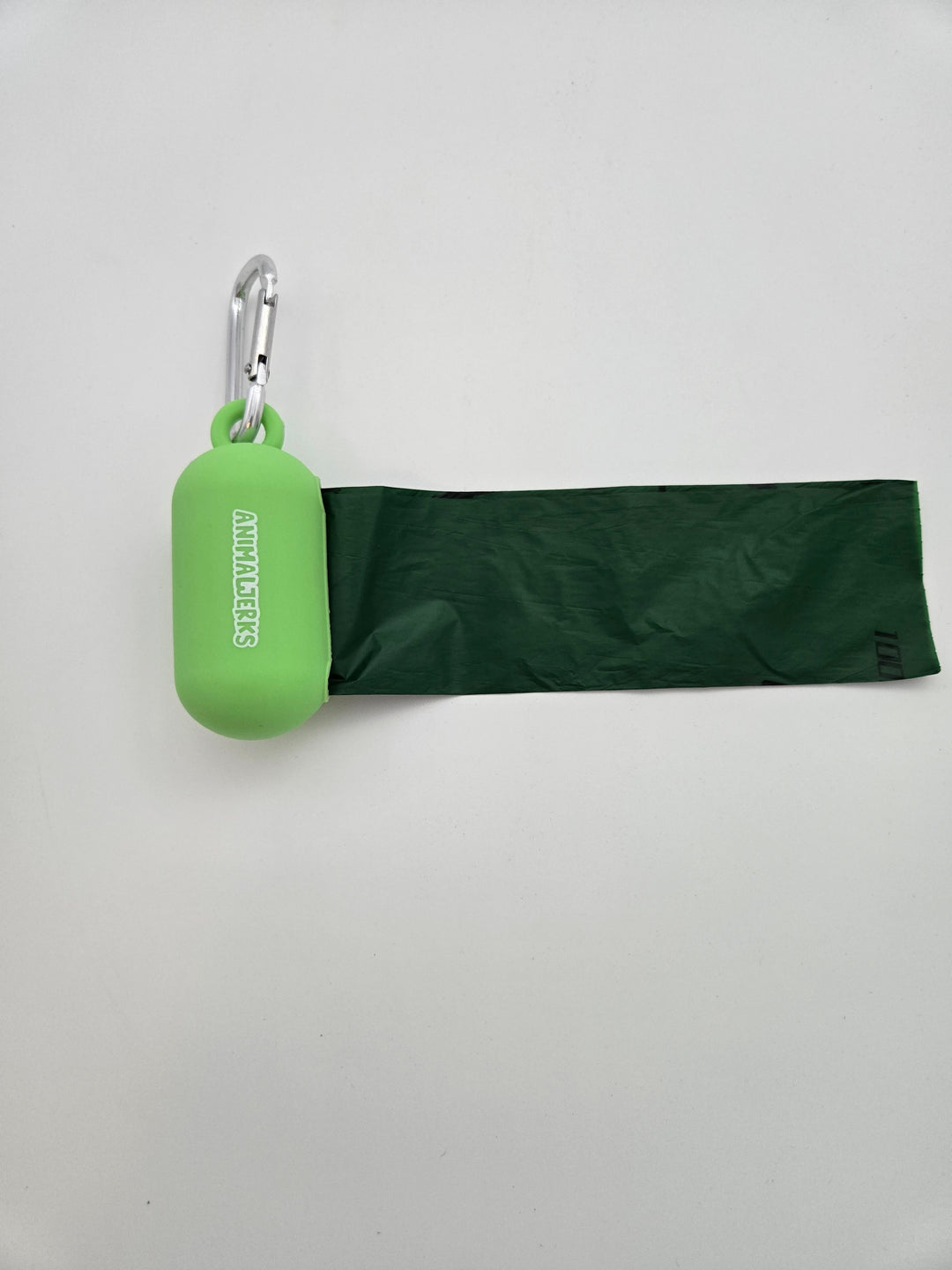 Green portable food grade silicone dog waste bag dispenser with clip comes with compostable and recycled rolls, shows bag pulled out
