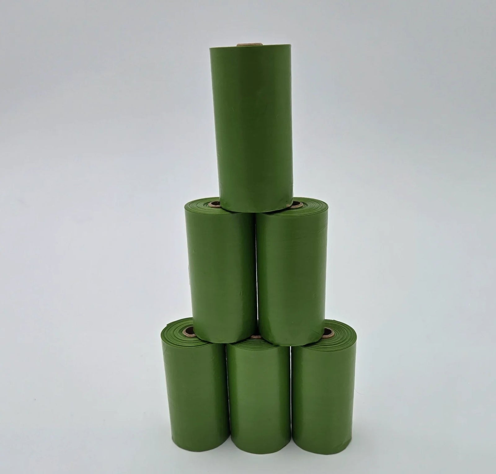Six rolls of 99% recycled plastic dog poop bags stacked eco-friendly pet waste