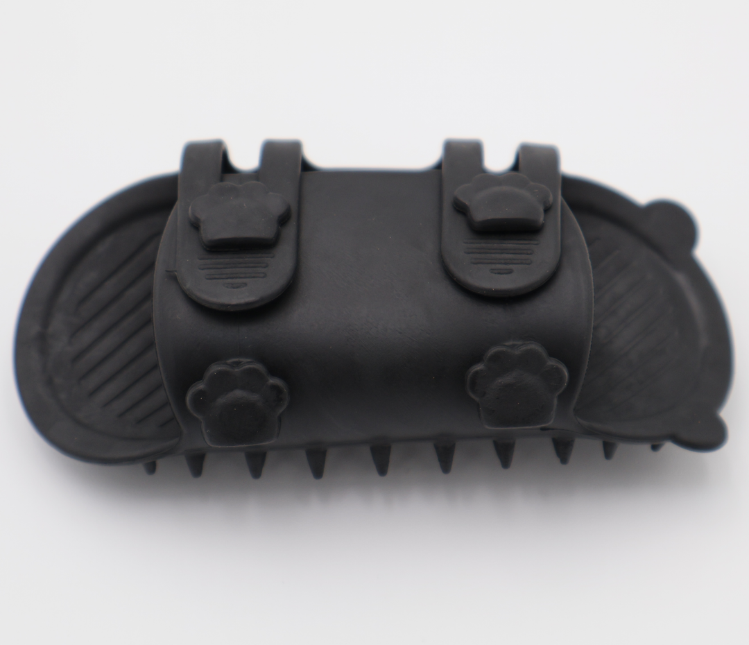 Black silicone cat grooming scratcher, underneath showing the two sizes if it was attached to a table leg. 