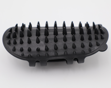 Black silicone cat grooming scratcher, showing what it would look like attached to a table leg. - thumbnail