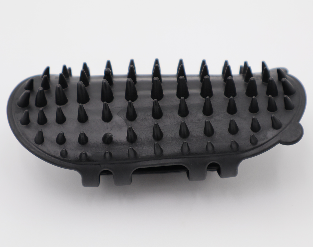 Black silicone cat grooming scratcher, showing what it would look like attached to a table leg.