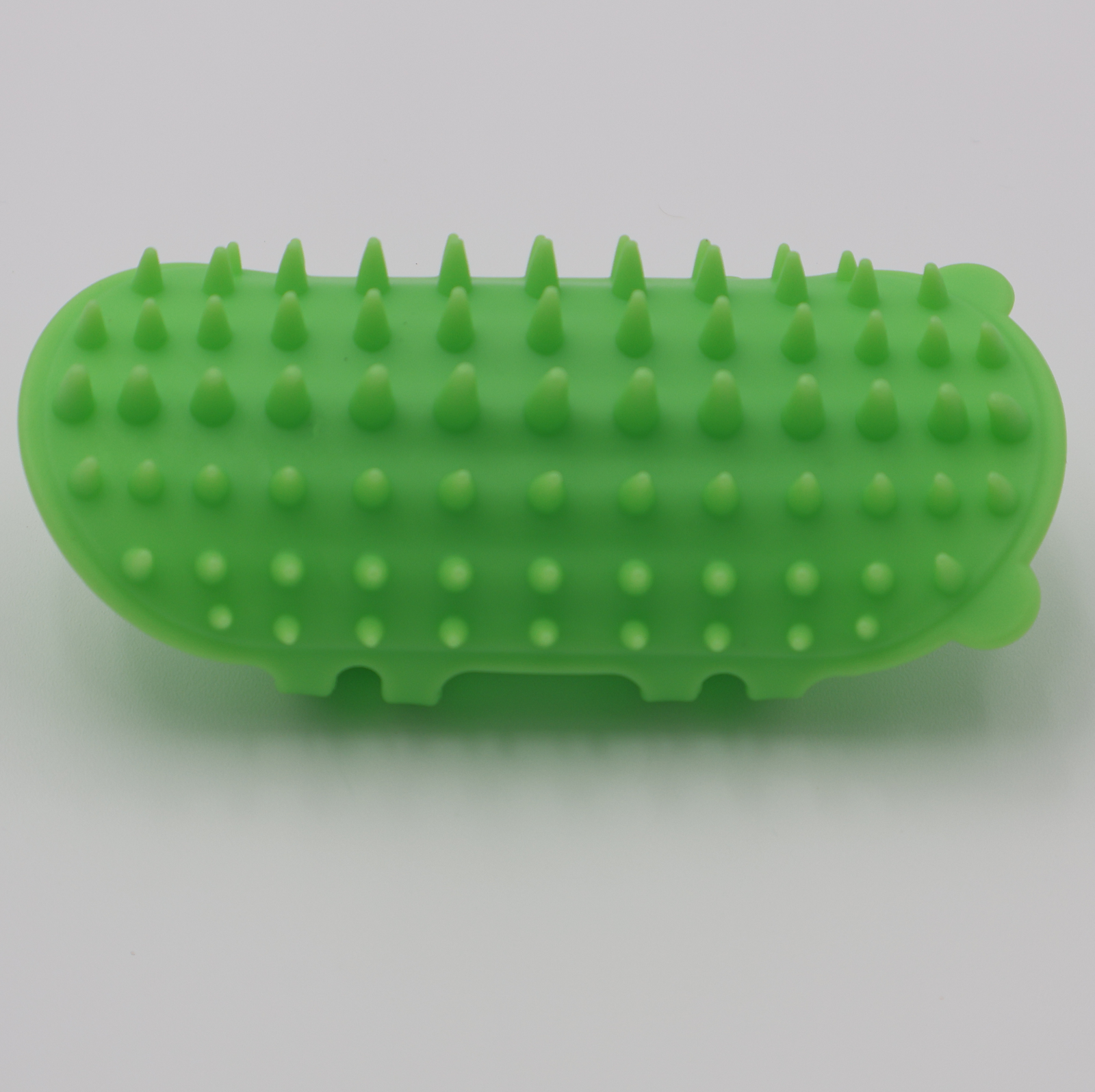 Green silicone cat grooming scratcher, showing what it would look like attached to a table leg. - alternate view