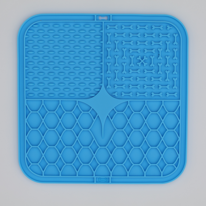 Blue food grade silicone dog licking mat with textured patterns for anxiety relief and slow feeding