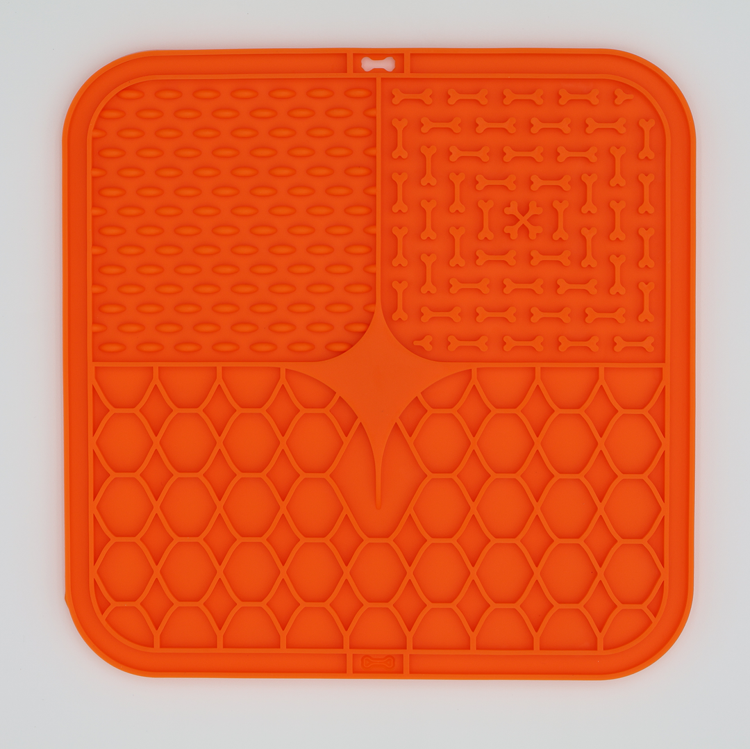 Orange food grade silicone dog licking mat with textured patterns for anxiety relief and slow feeding