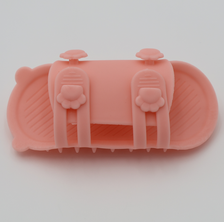 Pink silicone cat grooming scratcher, underneath showing the two sizes if it was attached to a table leg. 