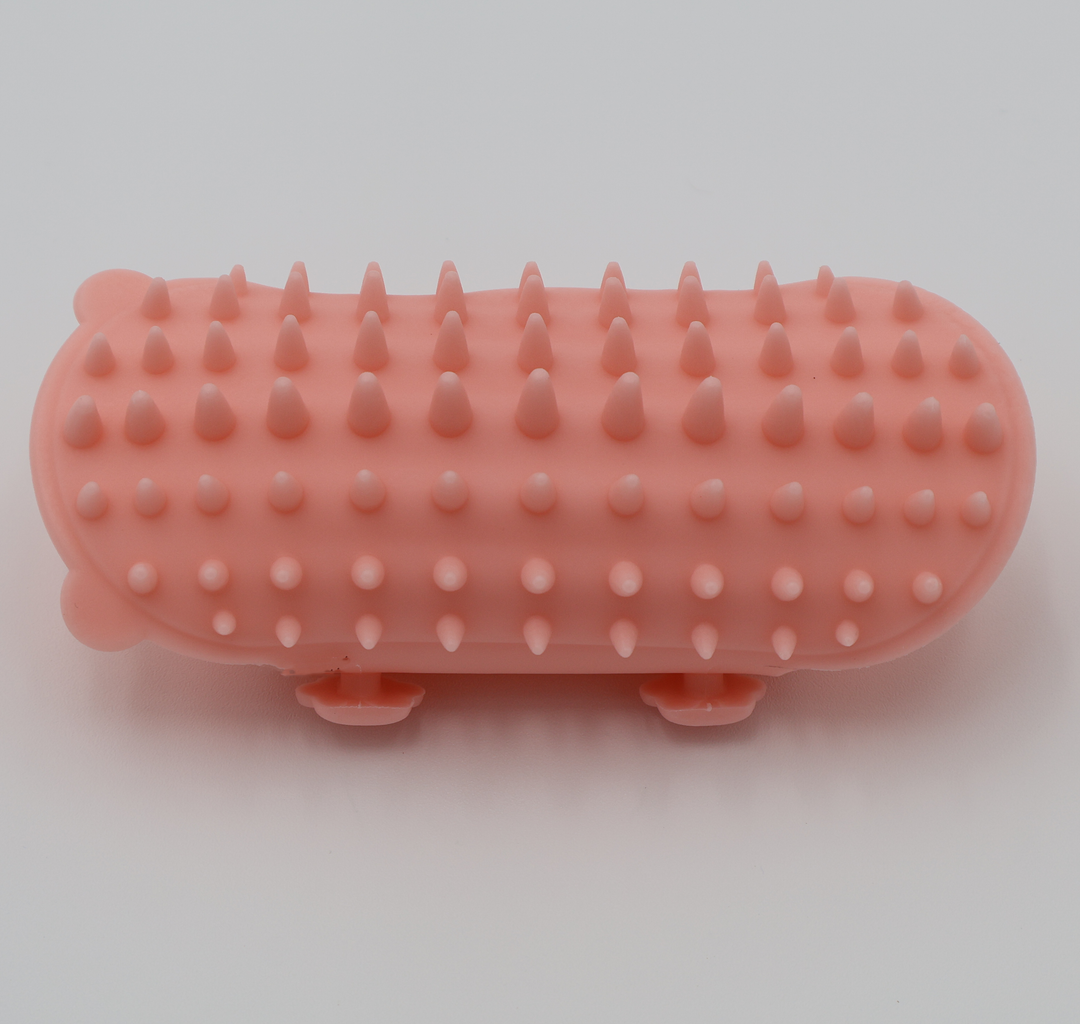 Pink silicone cat grooming scratcher, showing what it would look like attached to a table leg.