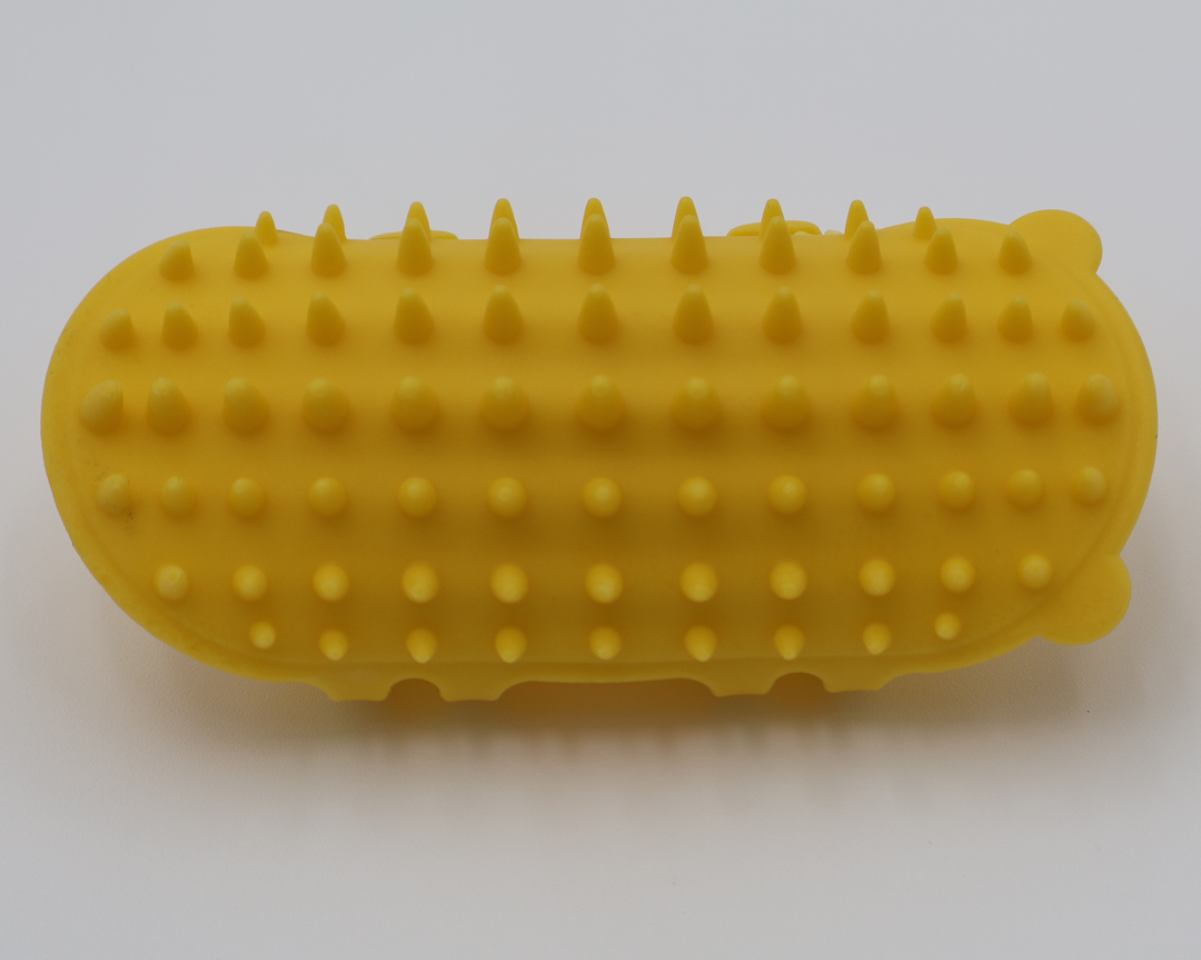 Yellow silicone cat grooming scratcher, showing what it would look like attached to a table leg.