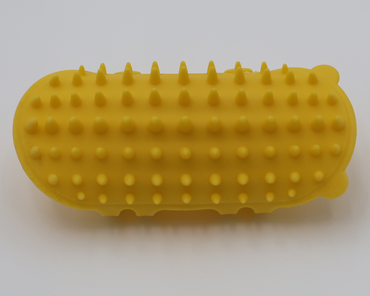Yellow silicone cat grooming scratcher, showing what it would look like attached to a table leg.